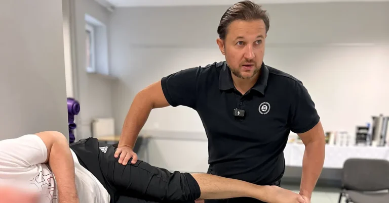 Physiotherapist applying the contract-relax technique to the leg of a patient lying on their side