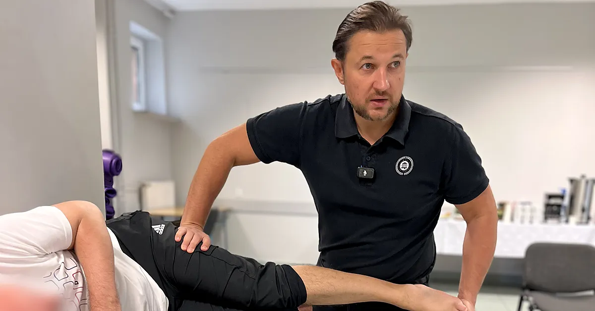 Physiotherapist applying the contract-relax technique to the leg of a patient lying on their side