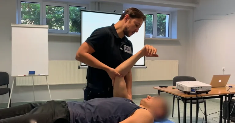 Physiotherapist assessing the elbow and shoulder of a patient lying supine, the arm held in shoulder and elbow flexion